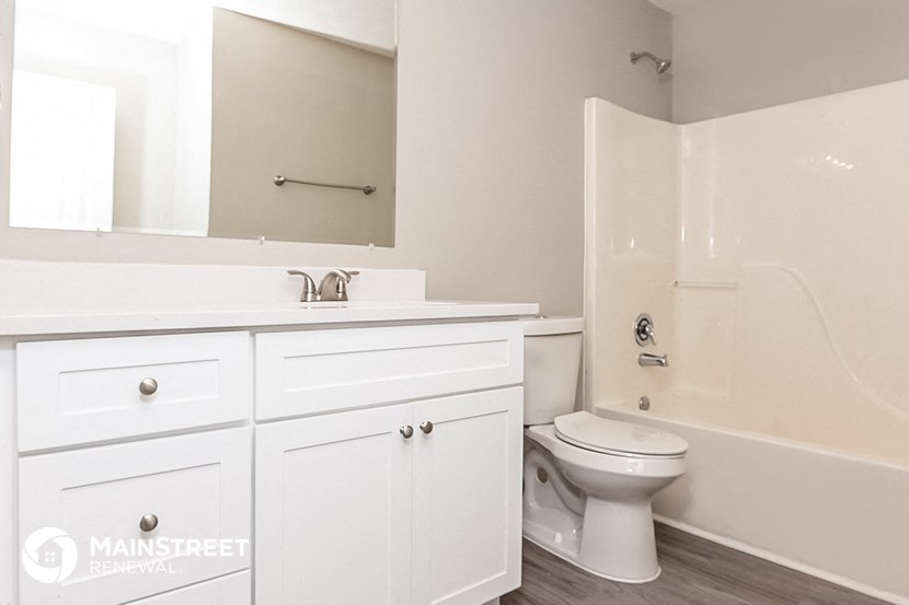 a white bathroom with a toilet and a sink