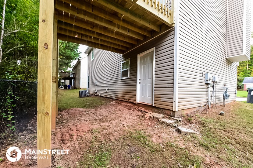 the back of a house with a porch and a white door
