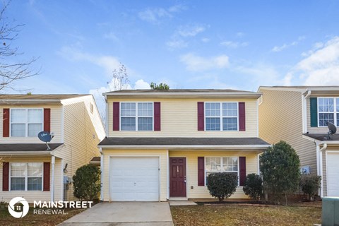 a yellow house with red shutters and a white garage door