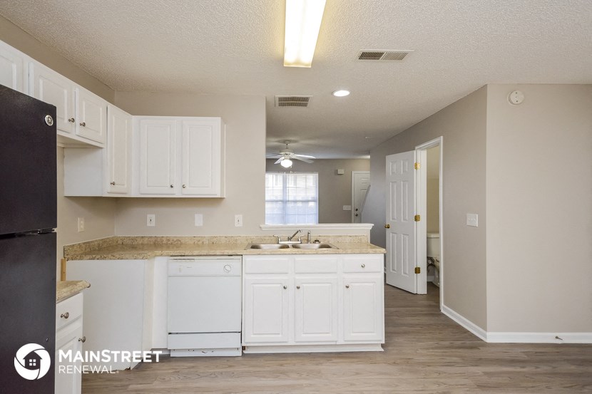 a kitchen with white cabinets and a sink and a refrigerator