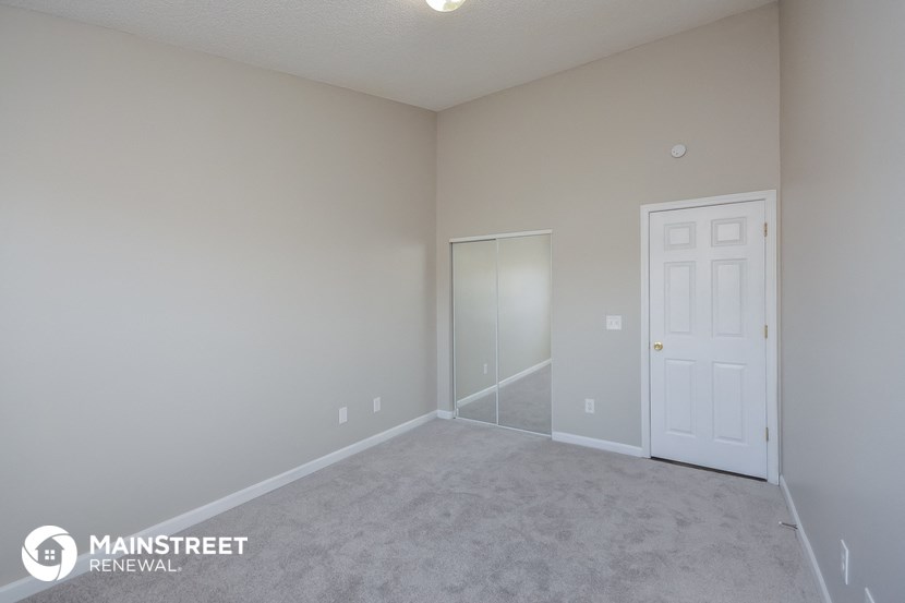 a bedroom with a white door and a carpeted floor