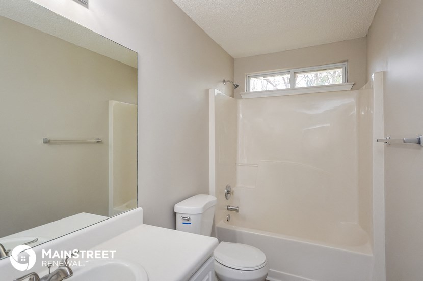 a small bathroom with a shower toilet and sink
