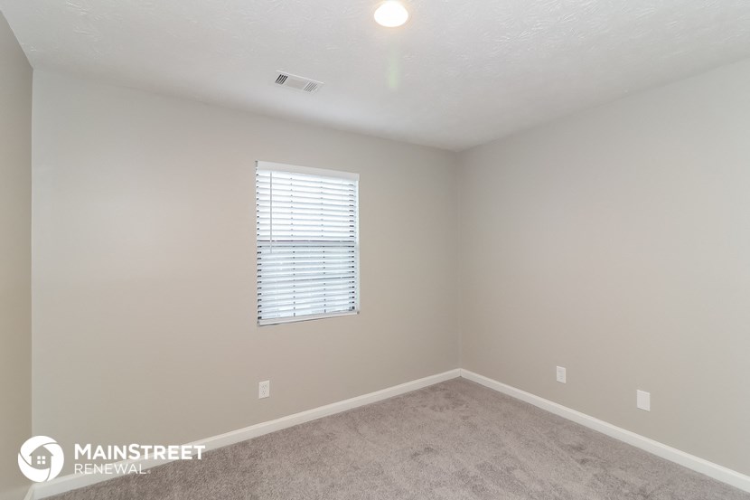a bedroom with a carpeted floor and a window