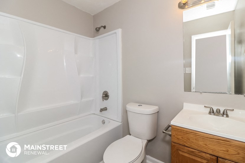 a white bathroom with a toilet and a tub and a sink