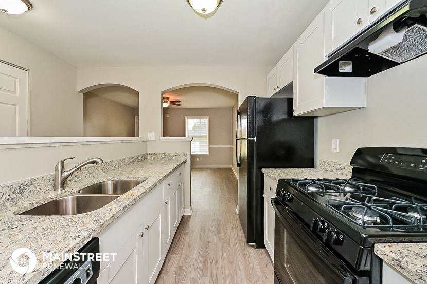 a kitchen with a stove and a sink and a refrigerator