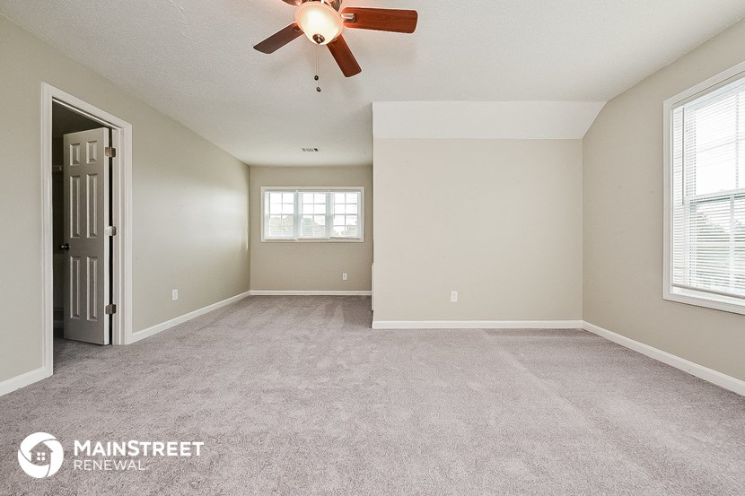 the living room of an empty house with a ceiling fan