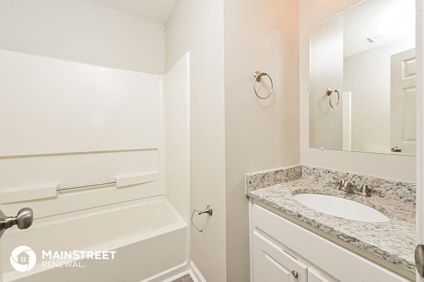 a bathroom with a sink and a bath tub and a mirror