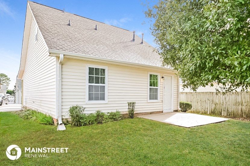 a small white house with a yard and a porch