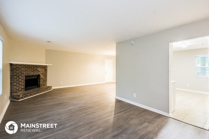 the living room and dining room with wood flooring and a fireplace