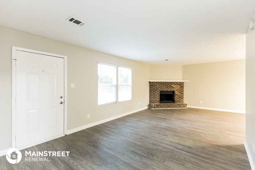 the living room of a home with wood floors and a fireplace