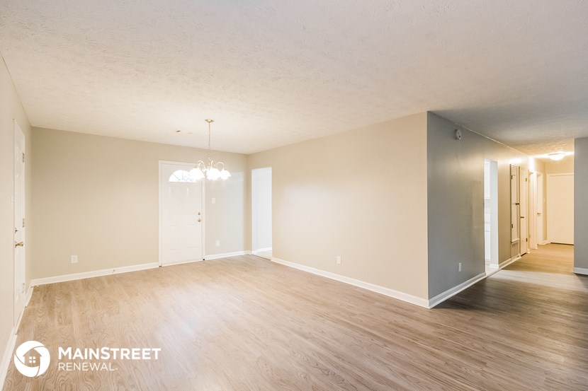 the living room and dining room of an apartment with wood flooring