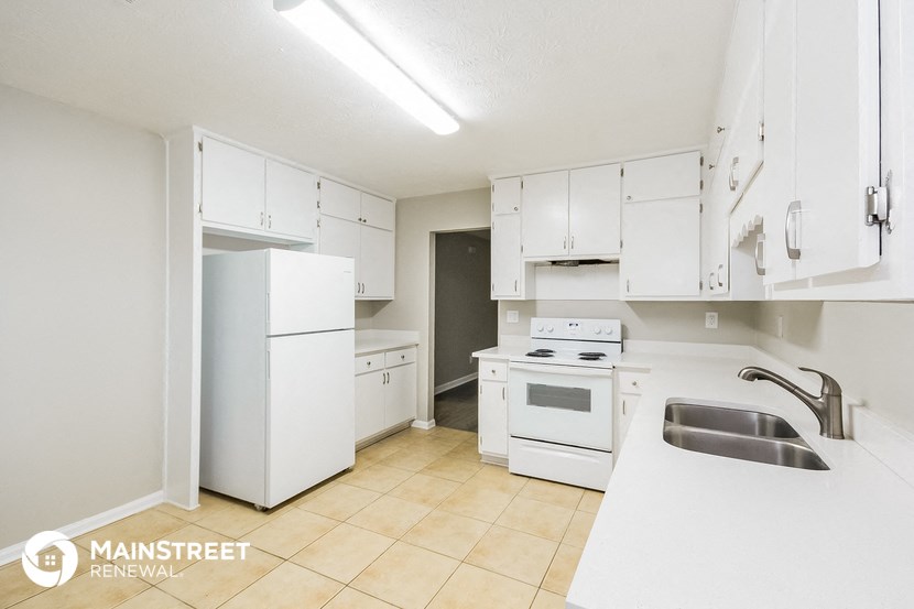 a kitchen with white appliances and white cabinets and a sink