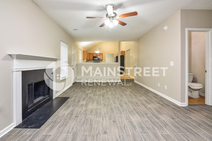 a living room with a fireplace and a ceiling fan