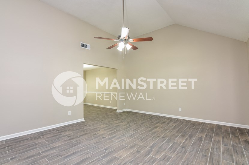 a living room with a ceiling fan and a window