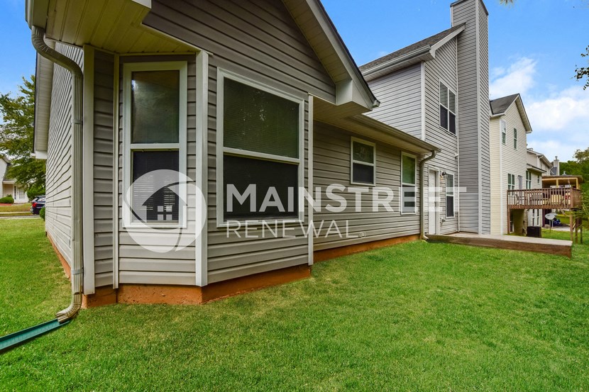 a side view of a house with a patio and grass