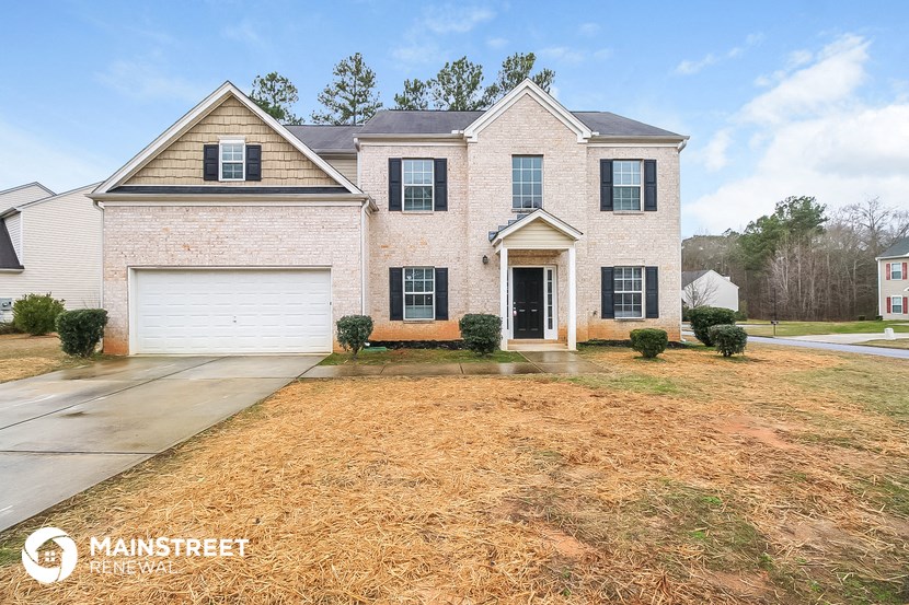 a white brick house with black shutters and a large yard
