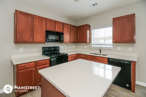 a kitchen with a white counter top and black appliances