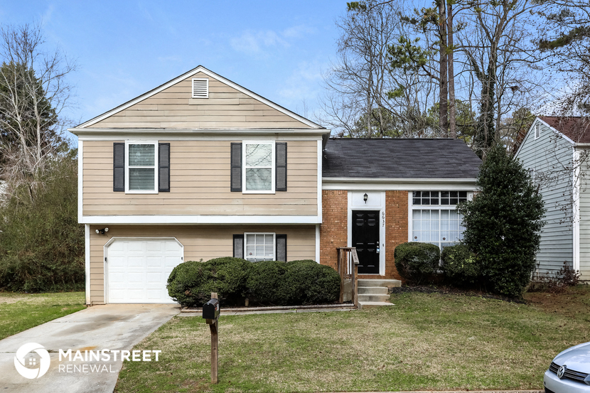 a tan house with a white garage door