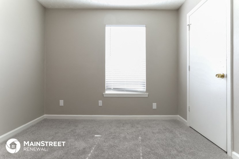 an empty room with a window and a door