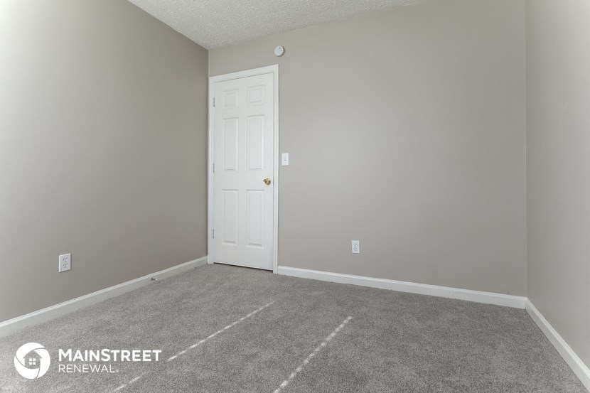 a room with a carpeted floor and a white door