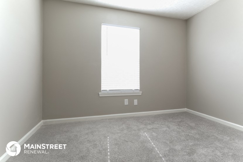 a room with a window and a carpeted floor