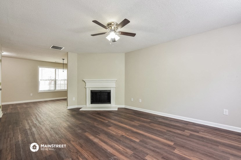 the living room with fireplace and ceiling fan
