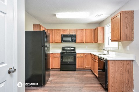 a kitchen with wooden cabinets and black appliances