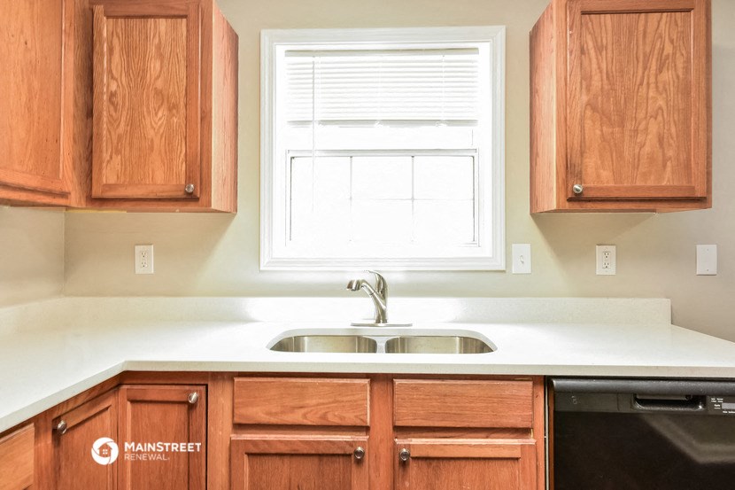 a kitchen with wooden cabinets and a sink and a window