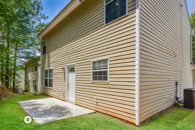 the side of a house with a garage and a driveway