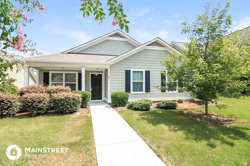 a white house with a sidewalk in front of it
