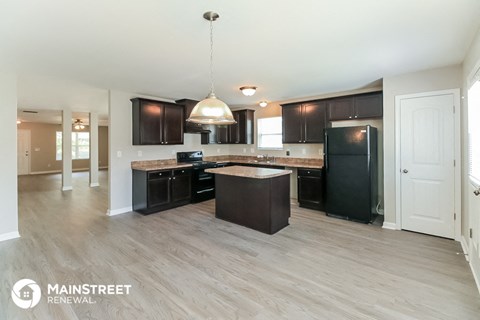 a large kitchen with black appliances and wooden cabinets