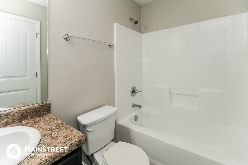 a bathroom with a white tub and a sink and a toilet