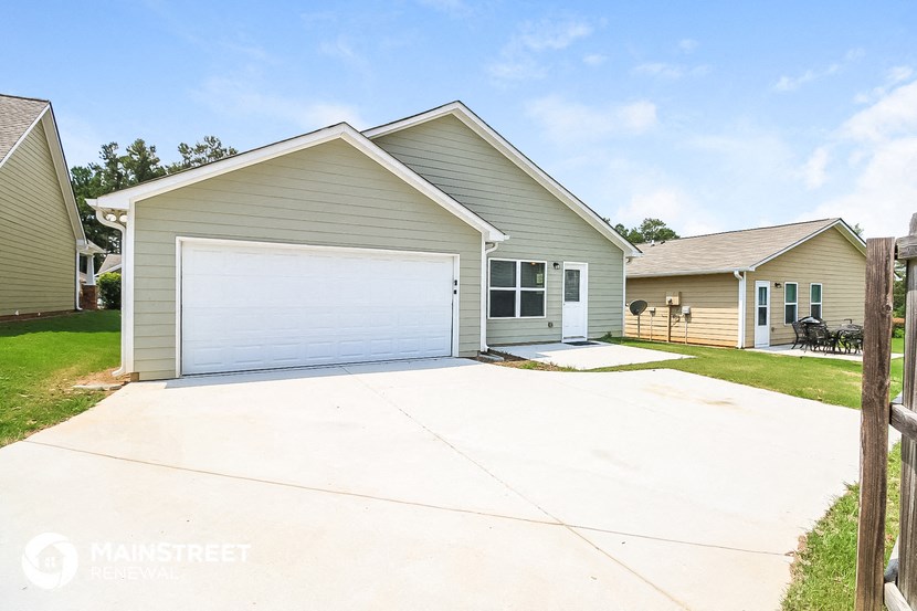 a gray house with a white garage door and a driveway