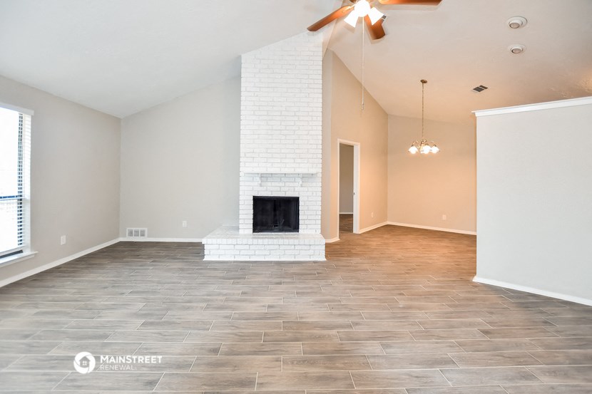 the living room with fireplace and tile flooring