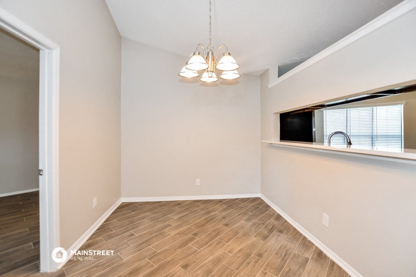 an empty living room with wood flooring and a window