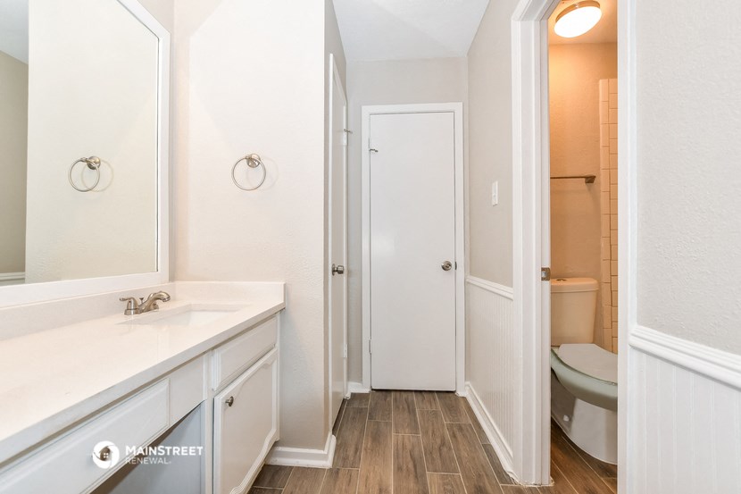 a bathroom with a mirror and a sink and a toilet