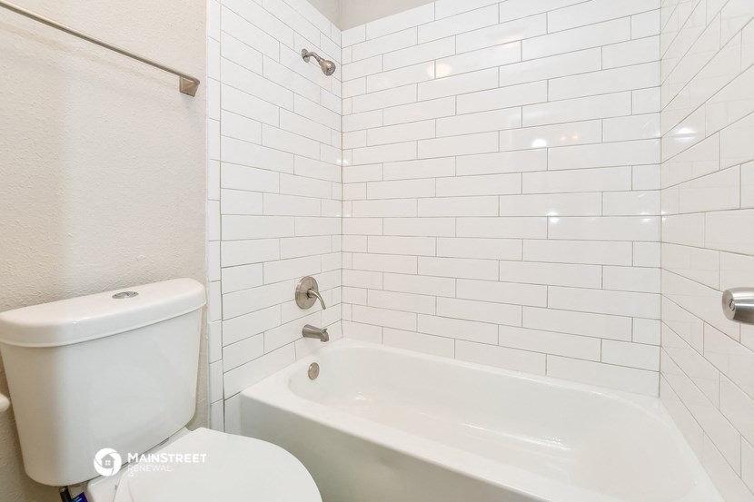 a white bathroom with a tub and a toilet