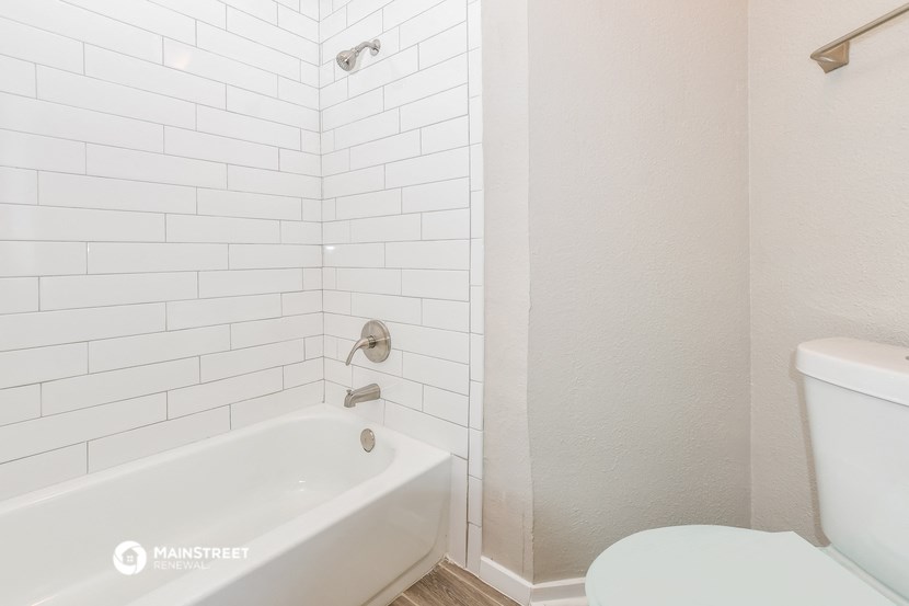 a white bathroom with a tub and a toilet