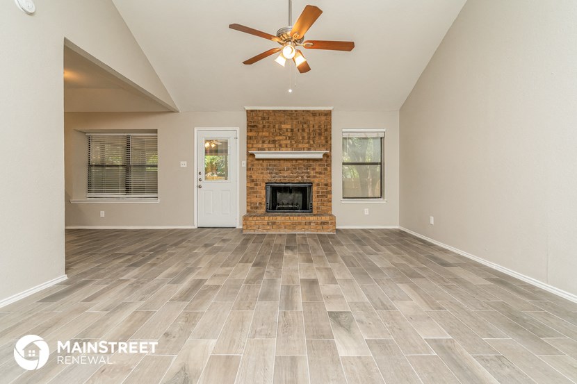 the living room with fireplace and tile flooring