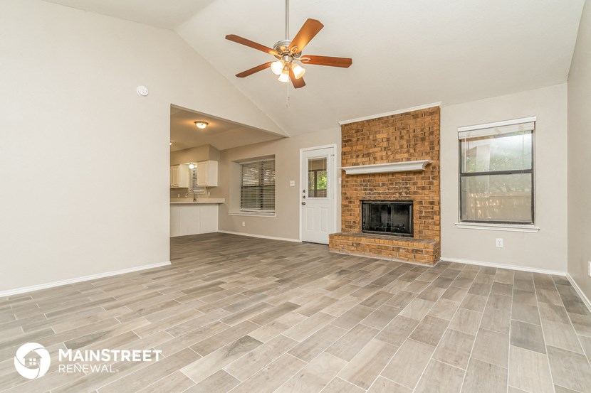 the living room with fireplace and tile flooring