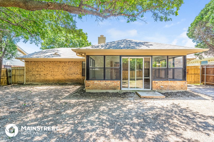 a small brick house with glass doors and a yard
