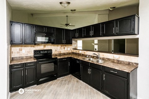 a kitchen with black cabinets and a sink