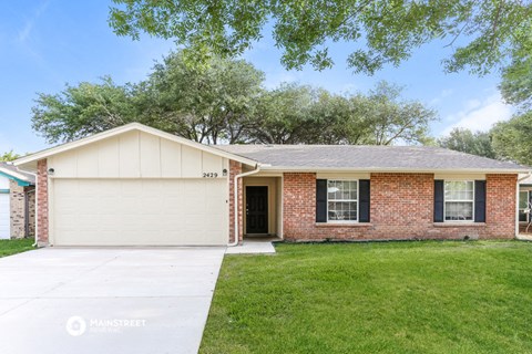 front view of a brick house with a white sidewalk