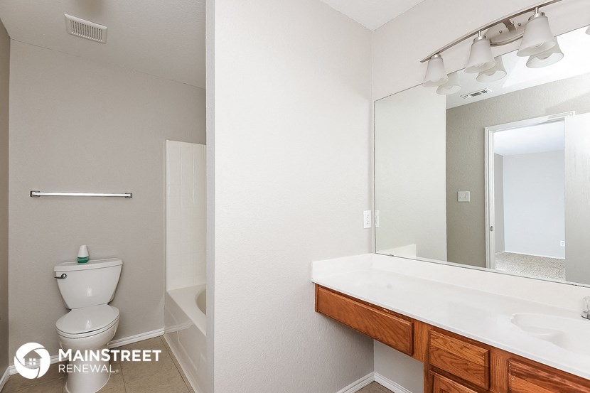 a bathroom with a large mirror and a toilet and a sink