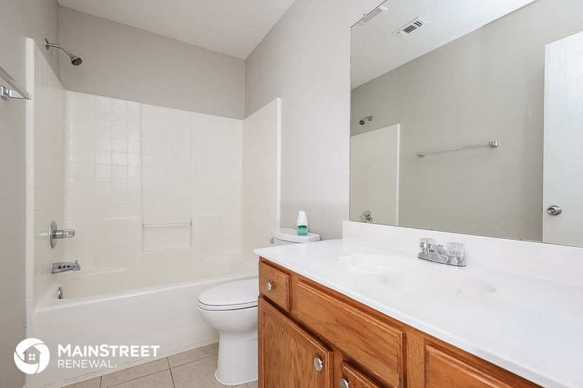 a bathroom with a sink toilet and tub and a mirror