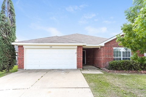 a white garage door in front of a brick house