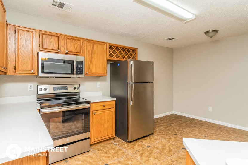 a kitchen with stainless steel appliances and wooden cabinets