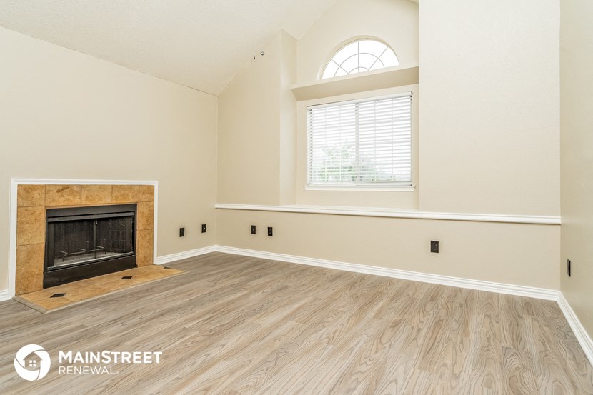 the living room of a new home with a fireplace and a window