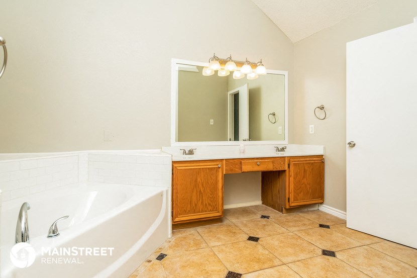 a bathroom with a tub and a sink and a mirror