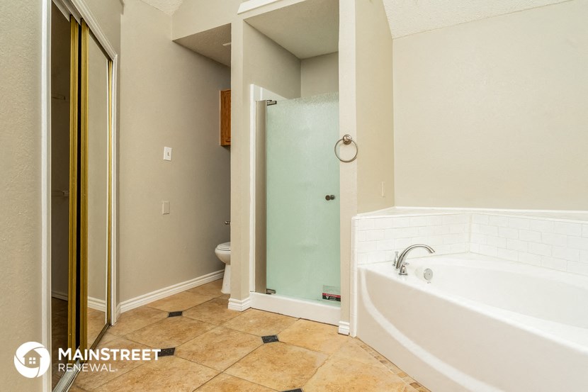 a bathroom with a tub and a shower and a toilet